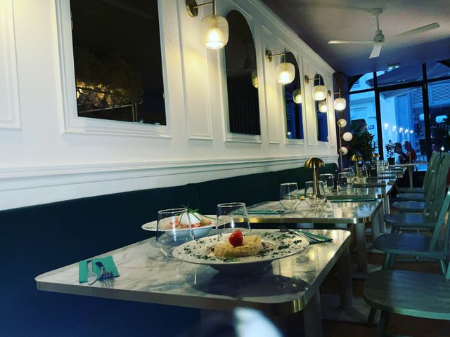 Terra d'Italia Salle à l'étage avec tables en marbre, chaises vertes et bar fleuri - Terra d'italia, restaurant italien Lyon 2